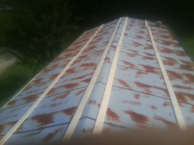 Rusted metal roof panels with new wood purlins before replacement — Storm Damage Roof Repair in Mont Belvieu by Roofing Brothers