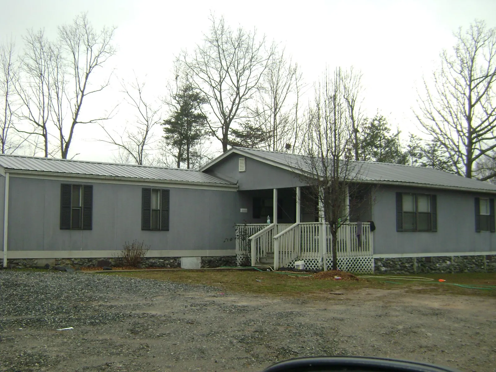 Metal roof over a manufactured home with a covered front porch in Mont Belvieu