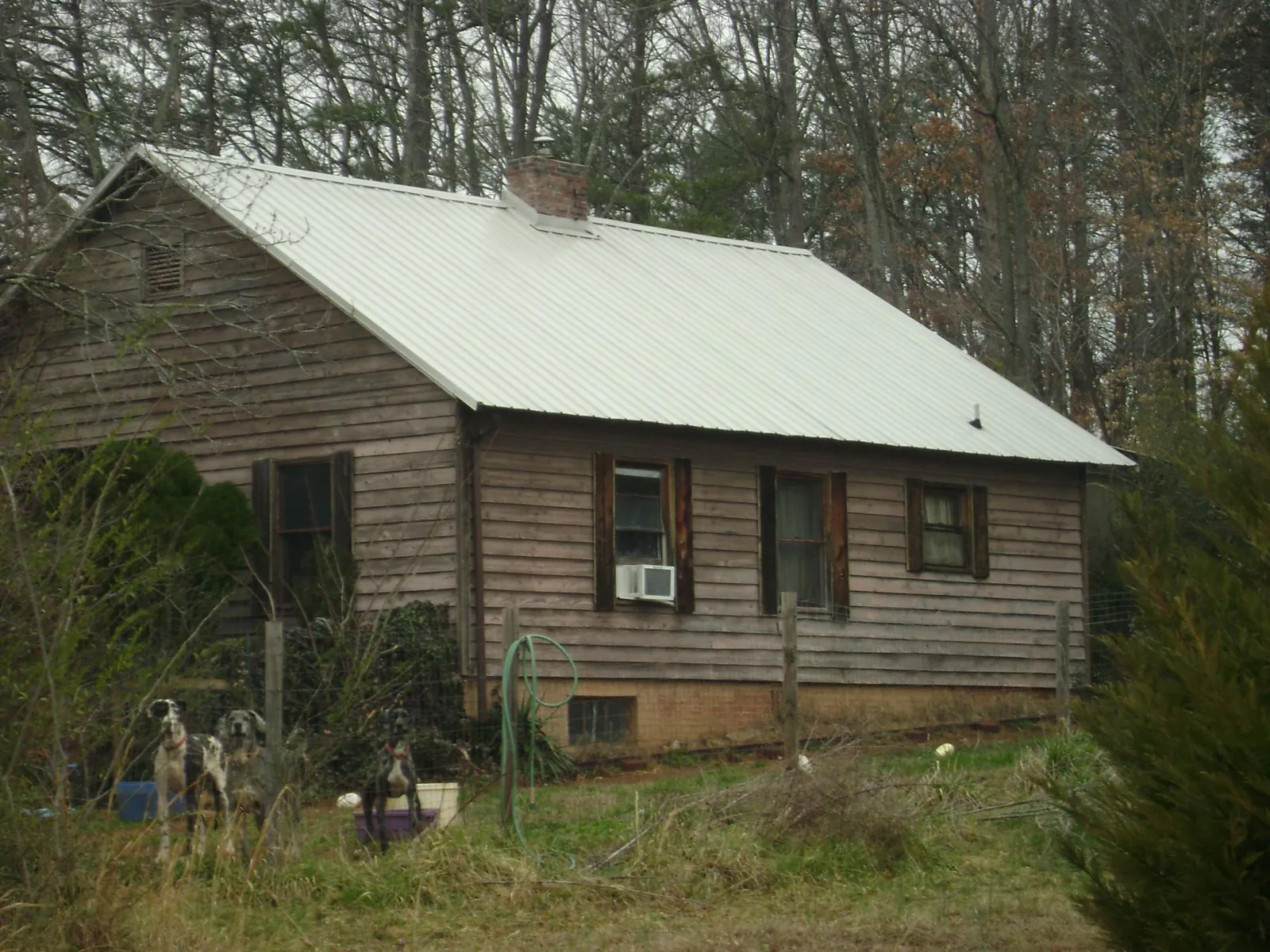 White metal roof on an old wood sided farmhouse, from a Metal Roof Installation job in Mont Belvieu